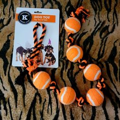 an orange and black dog toy laying on top of a tiger print blanket