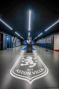 the inside of an office building with a logo on the floor and lights hanging from the ceiling