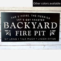 this sign is hanging on the side of a building that says, it's more the merier let's get toasted backyard fire pit sit long talk much laugh laugh laugh laugh laugh laugh laugh laugh laugh laugh