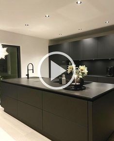 a large kitchen with black cabinets and white counter tops is featured in an advert