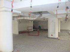 an empty parking garage with lots of hanging items on the ceiling and some trash cans