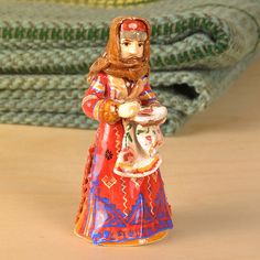 a ceramic figurine is sitting on a table next to a green mat and rug