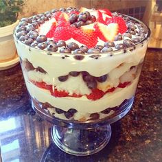 a trifle with strawberries and blueberries in it on top of a table