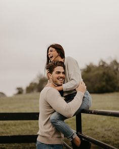 a man holding a woman on his back while she is smiling at the camera and texting instagram