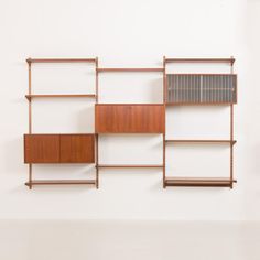 a wall mounted shelf with bookshelves and shelves on the side, against a white wall