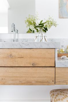 a bathroom vanity with marble top and wooden drawers