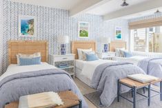 two beds in a room with blue and white wallpaper