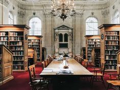 an old library with many bookshelves and chandelier