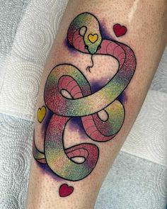 a colorful tattoo on the leg of a woman with a snake wrapped around it's neck