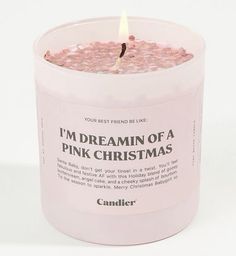 a pink candle that is sitting in a glass jar with the words i'm dreaming of a pink christmas written on it