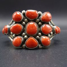 "VERDY JAKE (NAVAJO) BRACELET DESCRIPTION: This breathtaking cuff is from celebrated Dine' artisan Verdy Jake. Plump specimens of old red Mediterranean coral are set in heavy gauge sterling silver. This exqisite bracelet will be a cherished addition to your collection of fine vintage Native American jewelry. MEASUREMENTS: Interior of the cuff measures 5 3/8\" with an additional 1 1/8\" non-adjustable gap. Total circumference: 6 1/2\" Measures 2 1/4\" straight across the widest part (from wrist b Western Style Red Jewelry As Gift, Red Southwestern Cuff Bracelet Gift, Red Southwestern Cuff Bracelet As Gift, Red Southwestern Style Collectible Jewelry, Handmade Southwestern Red Cuff Bracelet, Handmade Red Southwestern Cuff Bracelet, Southwestern Style Adjustable Red Bracelets, Adjustable Red Southwestern Bracelets, Jewelry Measurements