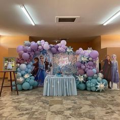 the balloon arch is decorated with blue and purple balloons, stars, and princesses