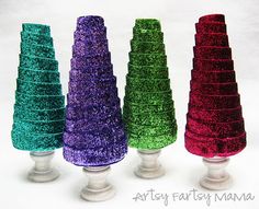 four different colored cakes sitting on top of each other in vases with the words arty farts mama written below them