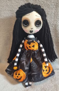 a doll with black hair wearing a halloween dress