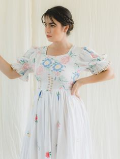 This stunning Upcycled Embroidered Vintage Tiered Dress is the perfect addition to any sustainable fashion lover's wardrobe. Made from a variety of vintage textiles, this dress features cotton/ linen fabric base and is accented with beautiful embroidery detailing around the neck. The puff sleeves and tiered design give a timeless, feminine look that is sure to turn heads. The dress also features various subtle hand embroidery in a variety of colors, as well as a bow tie detail at the back. This dress is perfect for pairing with statement jewelry and heels for a chic, sophisticated look.  One-of-a-kind upcycled maxi dress 19. 5" zipper at the back Fabric: Cotton/Linen  Care: Machine wash with cool water with a small amount of mild soap or liquid detergent. Dry at a lower heat and press with Embroidery Detailing, Liquid Detergent, Cotton Linen Fabric, Vintage Linen, Vintage Textiles, Feminine Look, Beautiful Embroidery, Embroidery Details, Tiered Dress