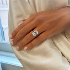 a woman's hand with a diamond ring on her left wrist, in front of a window