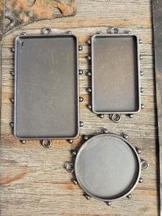 two metal plates sitting on top of a wooden table