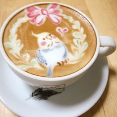 a cappuccino on a saucer decorated with flowers and a cat design