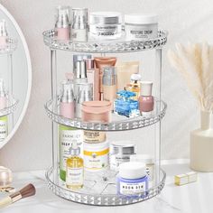 three tiered clear shelf with various beauty products on it