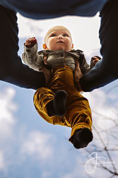 a man holding a baby up in the air