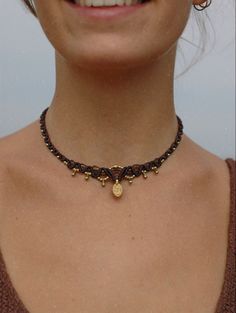 a close up of a woman wearing a necklace with gold charms on it's neck