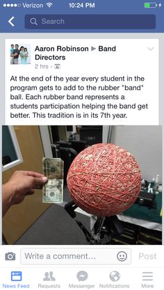 an image of someone holding money in front of a fake ball that is made out of yarn