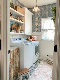 a washer and dryer in a small room with blue wallpaper on the walls