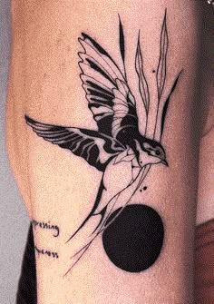 a black and white bird tattoo on the arm