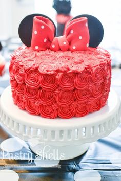 a minnie mouse cake is decorated with red roses