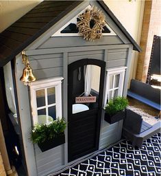 a doll house with windows and plants in the front door is decorated for christmas or new year's eve