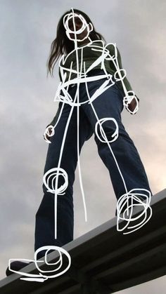 a woman standing on top of a metal structure with wires attached to it's sides