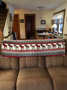 a living room filled with furniture and a large blanket on the back of it's couch