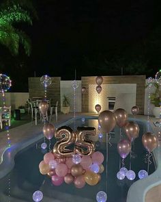 an outdoor pool with balloons and streamers in the shape of numbers