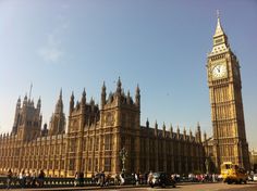 the big ben clock tower towering over the city of london, england as people stand in front of it