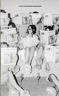 black and white photograph of people sitting on a couch with newspapers in front of them