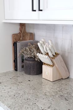 kitchen utensils sitting on top of a wooden block in the middle of a counter