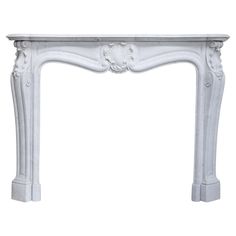 a white marble fireplace mantel with carvings