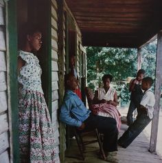 several people sitting on the porch of a house