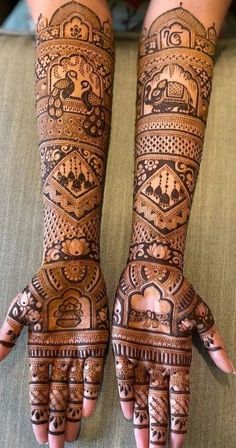 two hands with henna tattoos on them, one is showing the intricate pattern and the other has an elaborate design