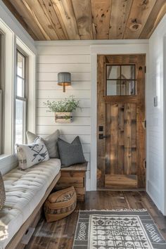 a living room with wood floors and a white couch in front of a wooden door