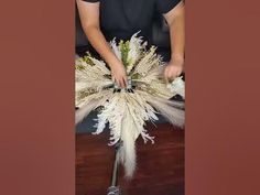 a man is arranging white flowers in a vase