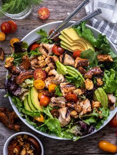 a salad with chicken, avocado and tomatoes