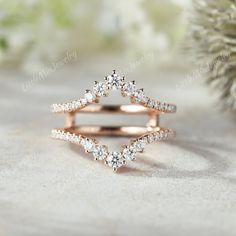 a rose gold ring with two rows of diamonds in the middle, on top of a white background