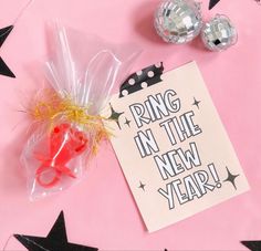 a new year's card and some scissors on a pink background with black stars