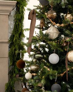 a decorated christmas tree with ornaments hanging from it's sides and ribbons on the top