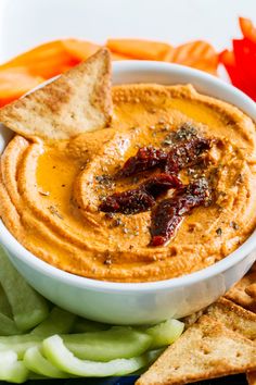 a white bowl filled with hummus and crackers