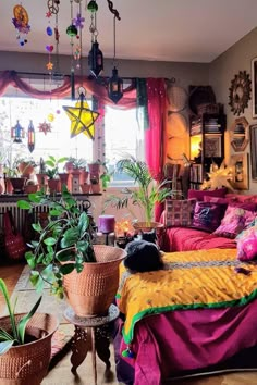 a living room filled with lots of furniture and plants on top of the couches