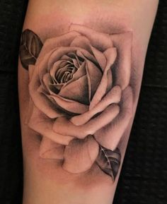 a black and white rose tattoo on the arm