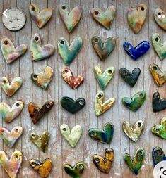 many heart shaped beads are arranged on a wooden surface