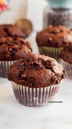 three chocolate muffins sitting on top of a counter